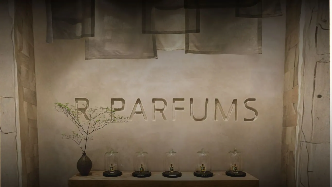 A wall engraved with the words R PARFUMS