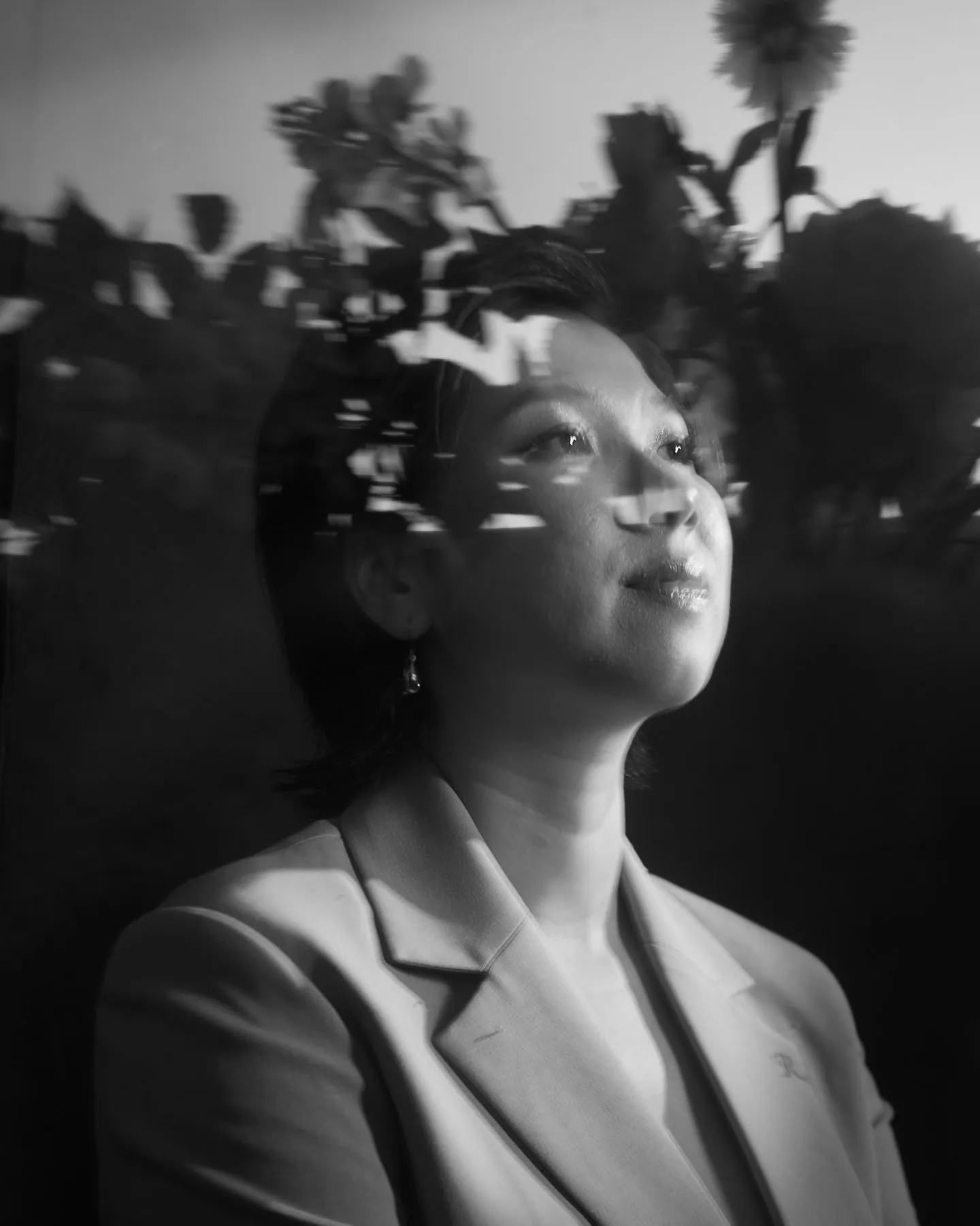 Rei Nguyen, a black-and-white portrait with the shadow of flowers across her face, 2026