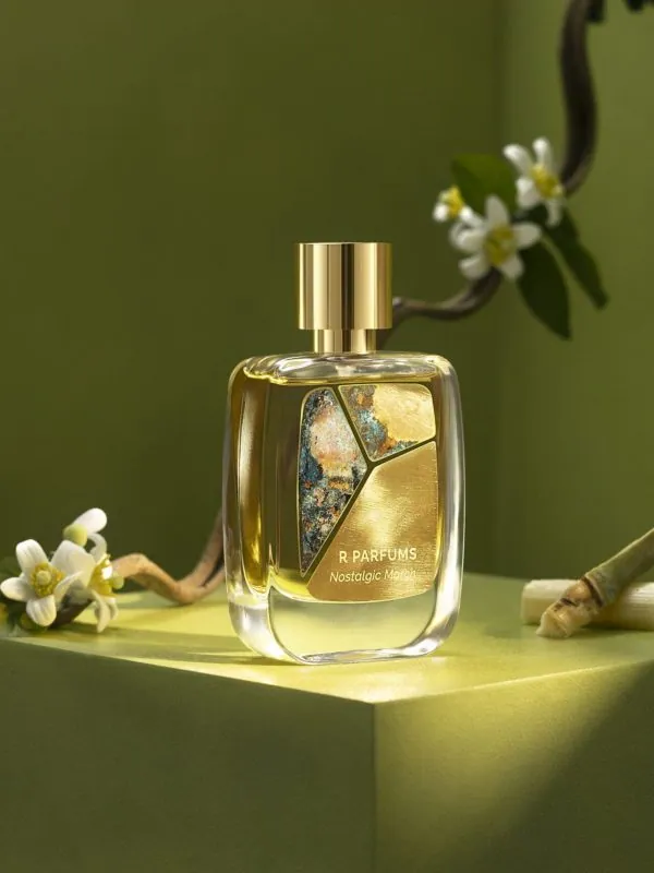 R Parfums Nostalgic March 병, 노란 꽃술의 흰 꽃가지와 사탕수수 한 토막, 올리브그린 배경