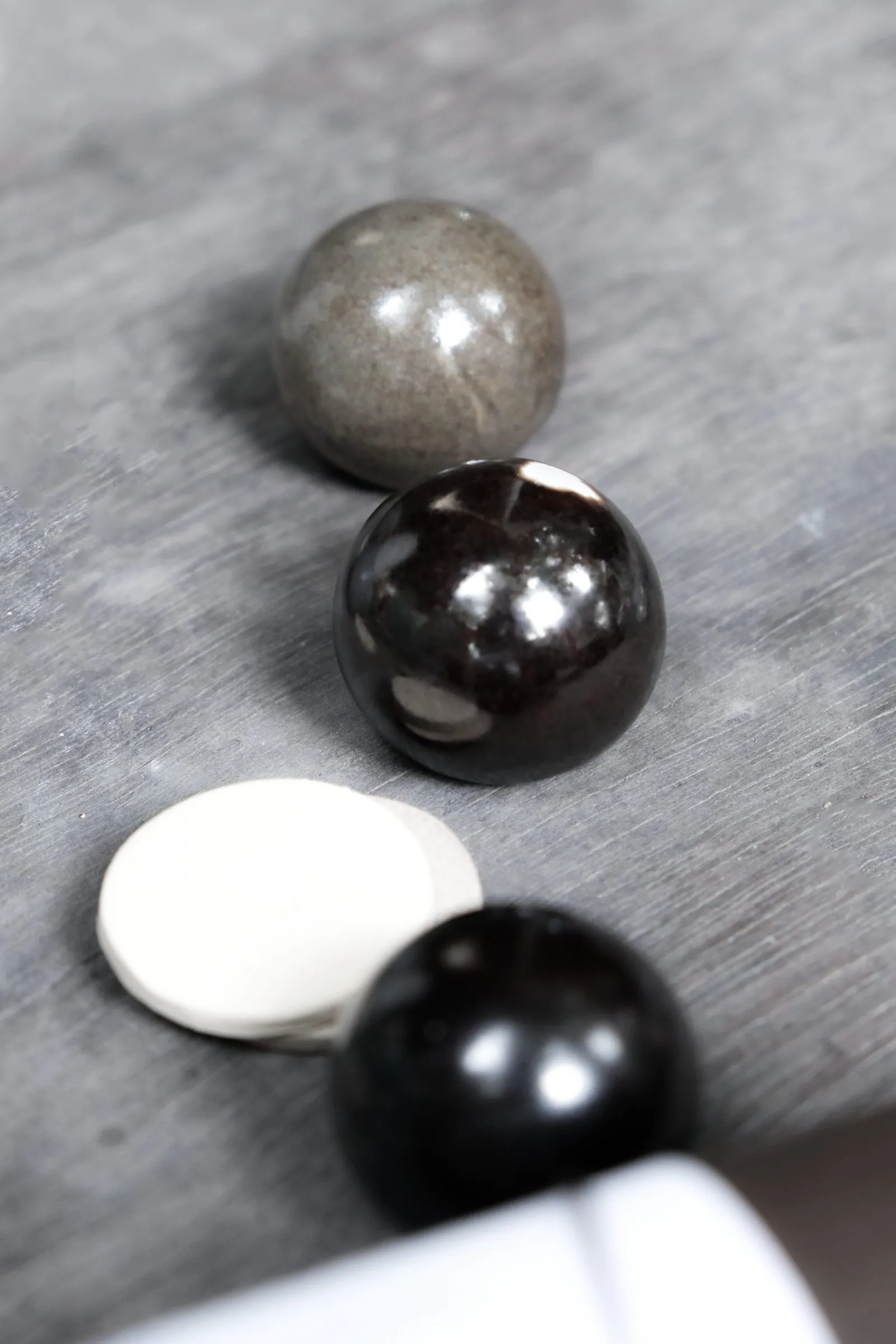 Glossy grey and glossy black spheres and a cream disc, seen from above