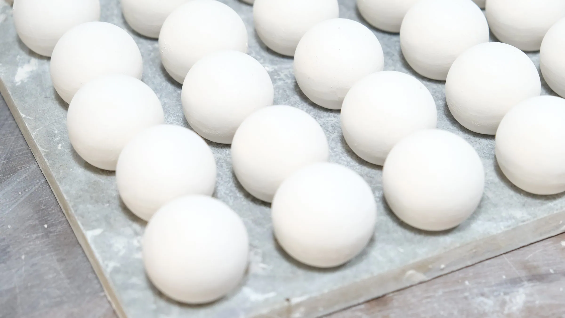 White spheres on a board in close-up, the background out of focus