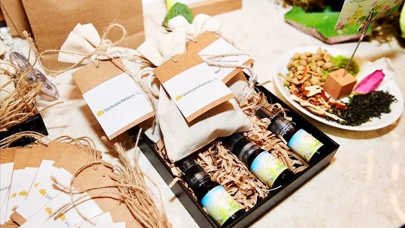 Vietnam Airlines gift pouches and a box of three Nhã oil vials beside tea, young rice and lotus seeds