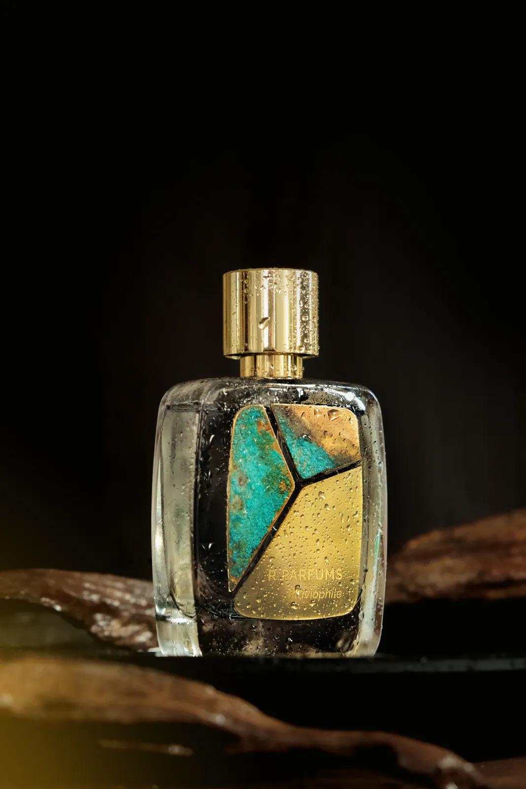 Pluviophile 香水瓶凝着水珠,松石绿与金铜色交错的 Patina 铜片,衬在深色背景上。