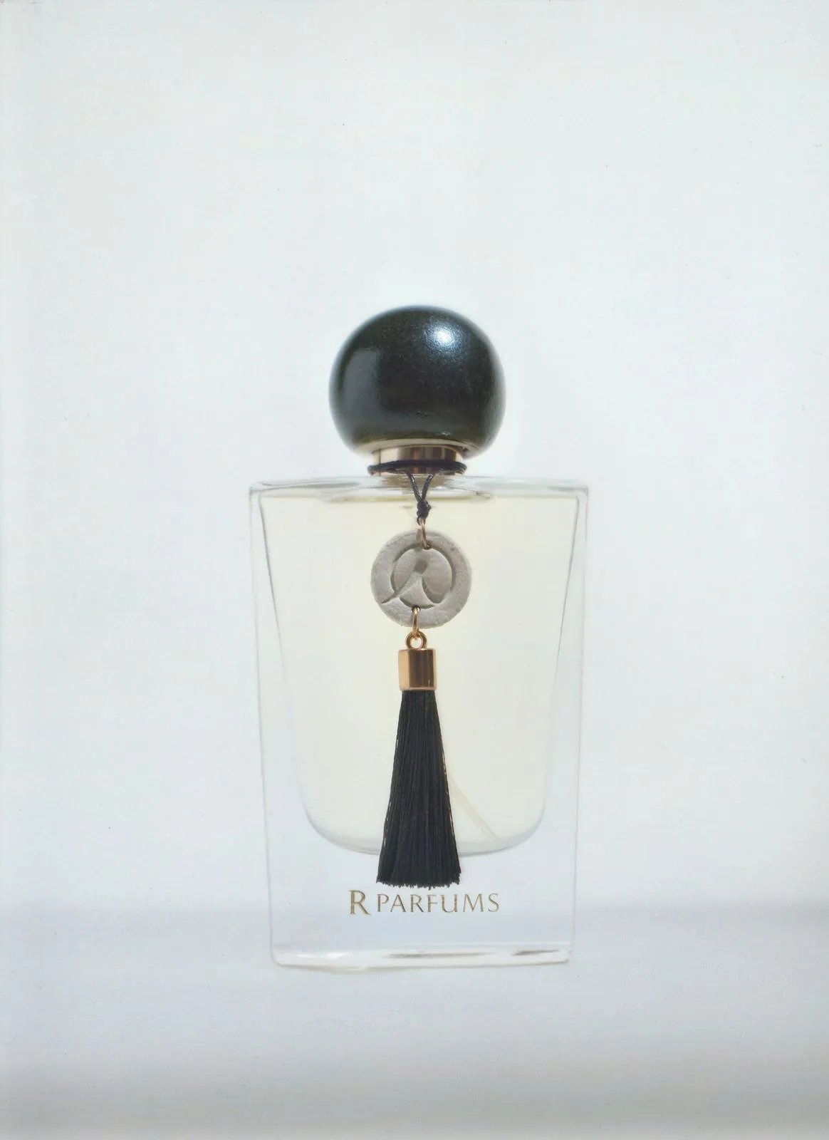 Botol Seramik dengan penutup bersayu hitam, jumbai hitam dan loket seramik berukir huruf R