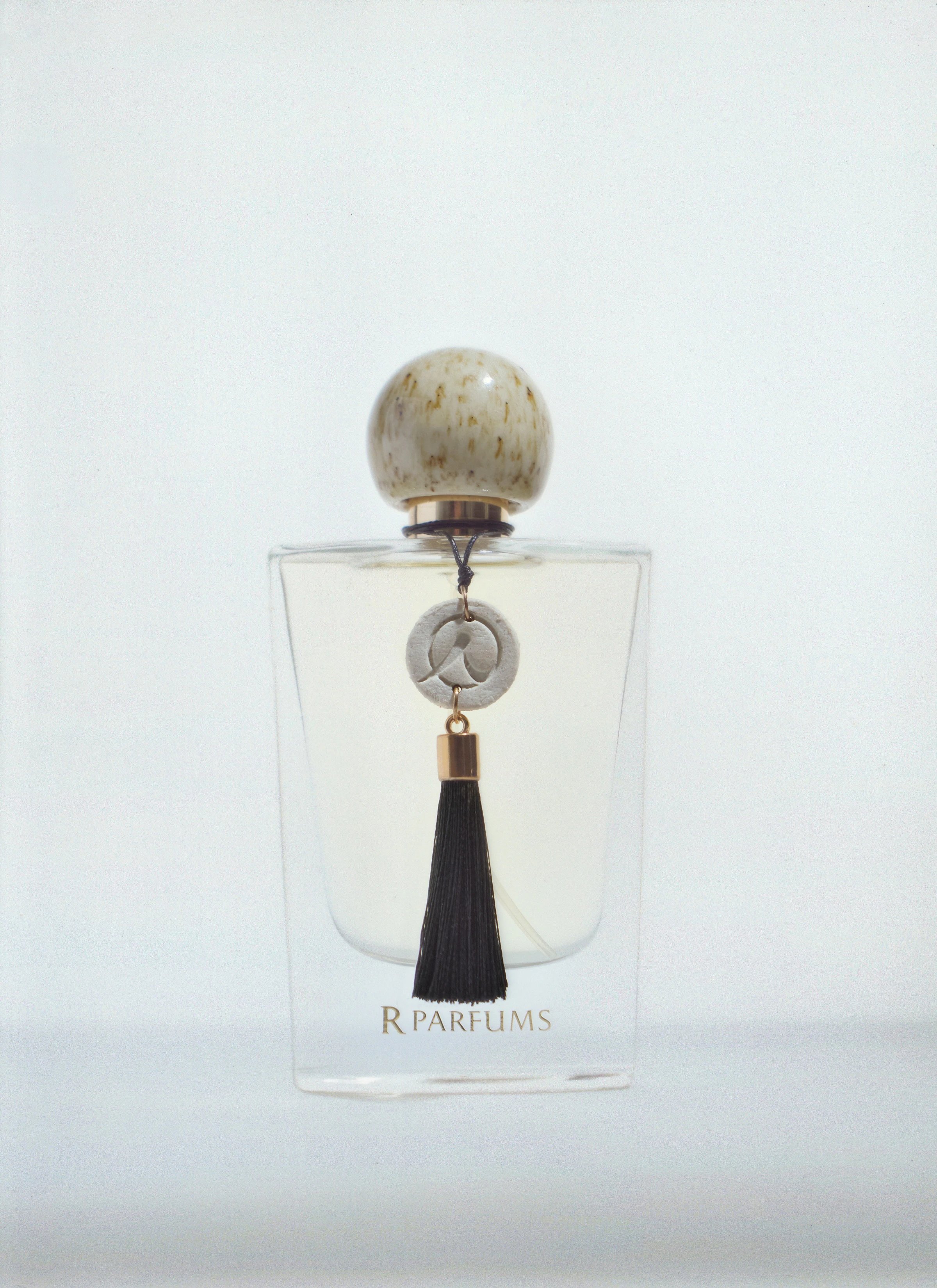 The Ceramic bottle: a speckled glaze cap and a black tassel, on a light ground