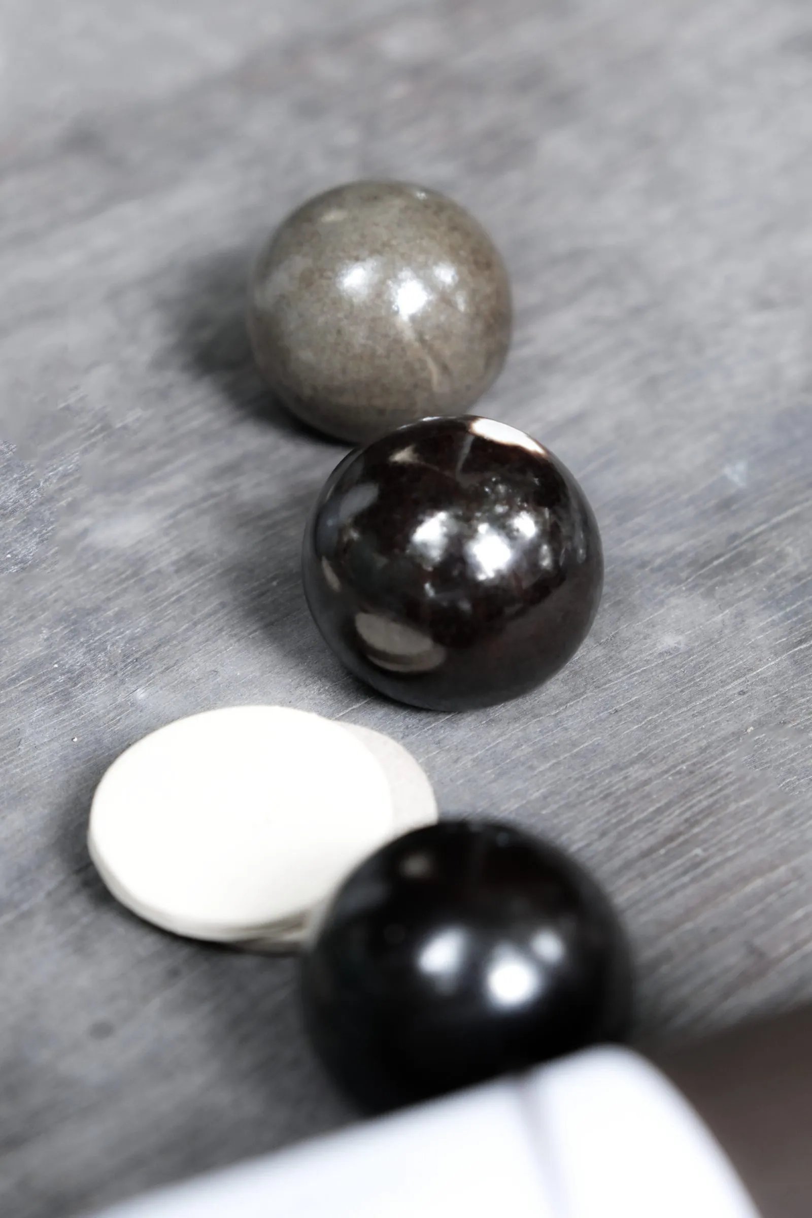 Sfera kelabu berkilat dan hitam berkilat serta cakera krim, dilihat dari atas
