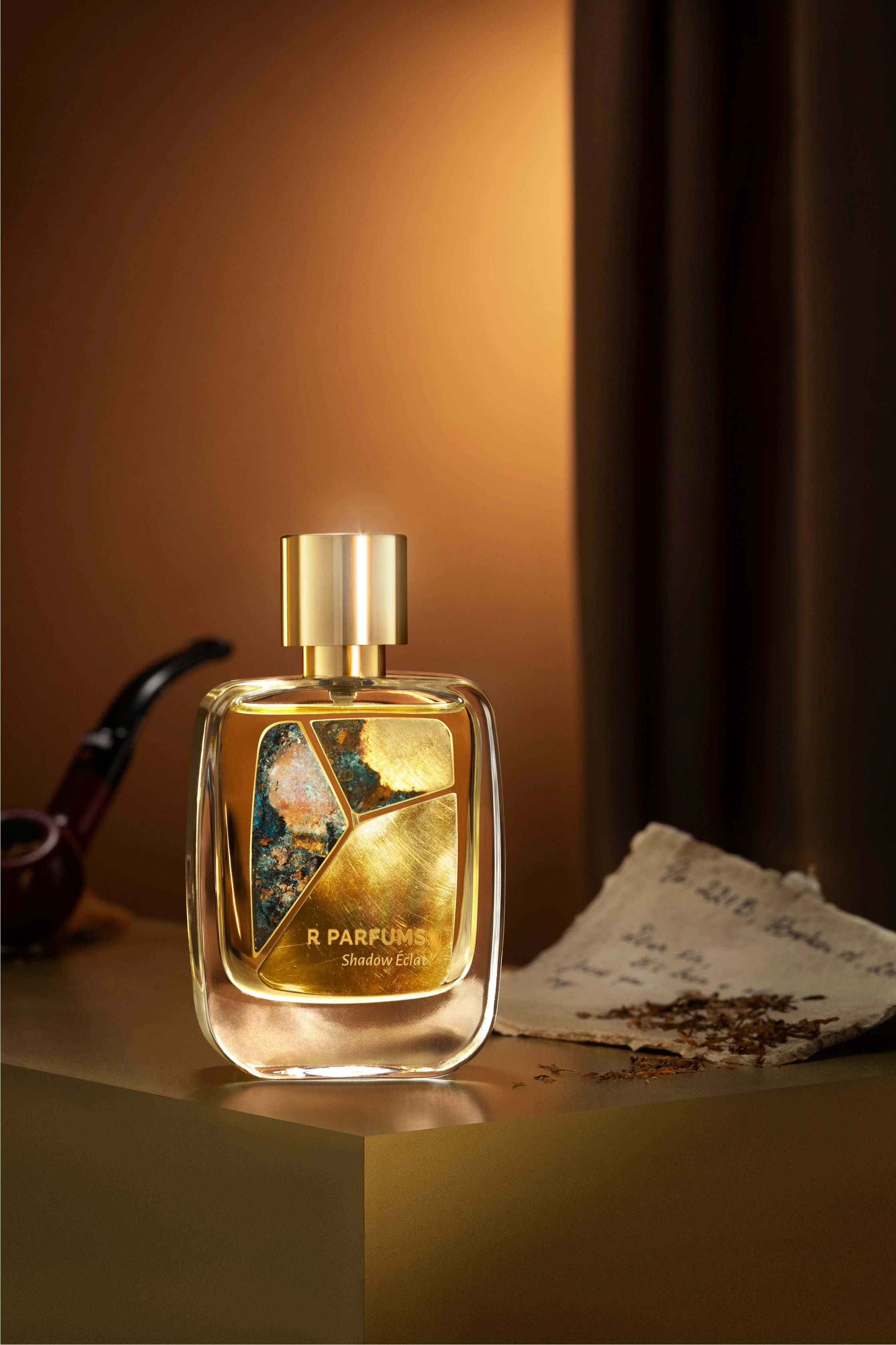 221B in the Patina bottle: three pieces of brass set on the glass, on a dark ground